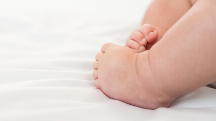 Close up of foots baby in a room with a lot of sunlight. The newborn sleeping