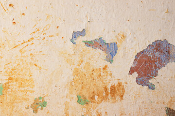 Peeling paint on an old orange-yellow colored wall