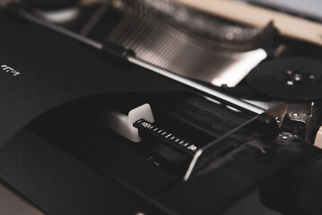 Top view of vintage typewriter with black paper and white ink. Closeup 1970 typewriter.