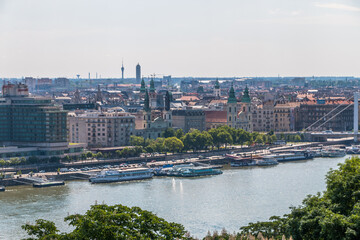 Fototapeta na wymiar Top view of the city of Budapest in Hungary, the Danube river, bridges, the Parliament building on a warm sunny day.