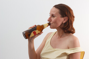 Female alcoholism. Woman drinking beer on the white background