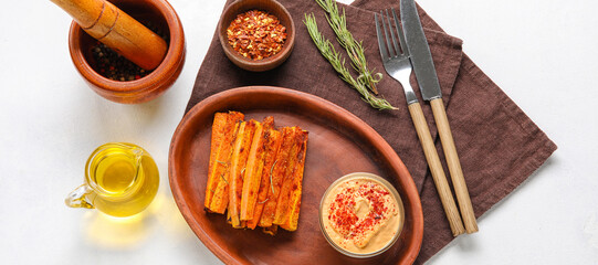 Plate with tasty baked carrots and sauce on white background