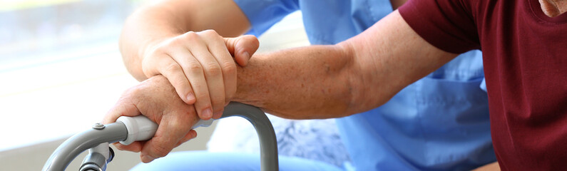 Elderly man with caregiver at nursing home, closeup