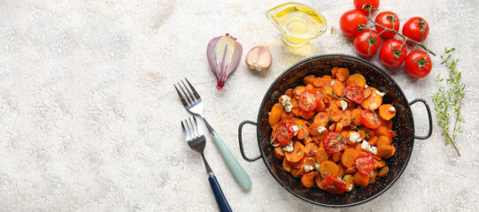 Frying pan with tasty cooked carrots and tomatoes with spices on grunge background with space for text