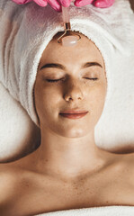 Woman receiving facial massage treatment with jade roller. Girl facial treatment. Skin care. © Strelciuc