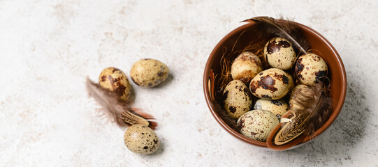 Bowl of fresh quail eggs on light background with space for text