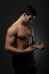 Muscular man with a syringe in his hand. User of anabolic steroids for strength training.