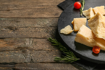 Board with pieces of tasty Parmesan cheese and tomatoes cherry on wooden background, closeup