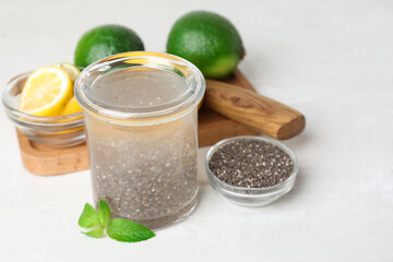 Glass with healthy drink, chia seeds and citrus fruits on white table