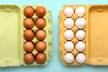 Holders with brown and white chicken eggs on color background