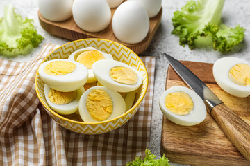 Bowl with halves of boiled chicken eggs on table