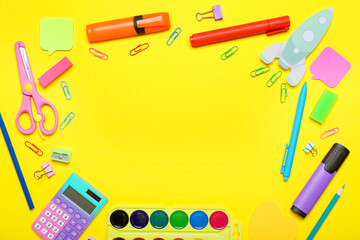 Frame made of paper rocket with school stationery on yellow background