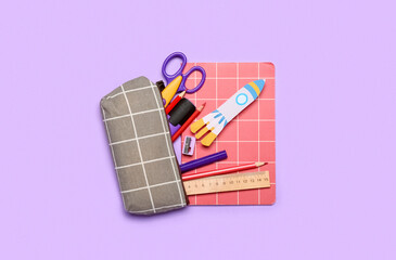 Pencil case with paper rocket and school stationery on violet background