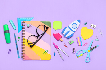 Paper rocket with school stationery and eyeglasses on violet background