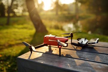 A drone ready to take off from a bench in a park on sunny autumn morning.