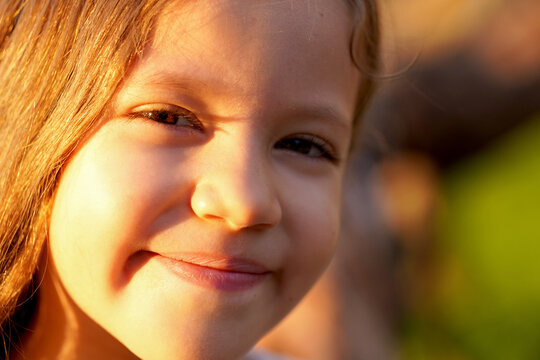 rostro cara de ni&ntilde;a feliz sonriente alegre posando con una hermosa mirada disfrutando en el parque al aire libre de un bello atardecer