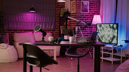 Nobody at empty desk with streaming equipment to broadcast live interview on social media channel. Podcast production studio with professional microphone and headphones for streaming internet radio.