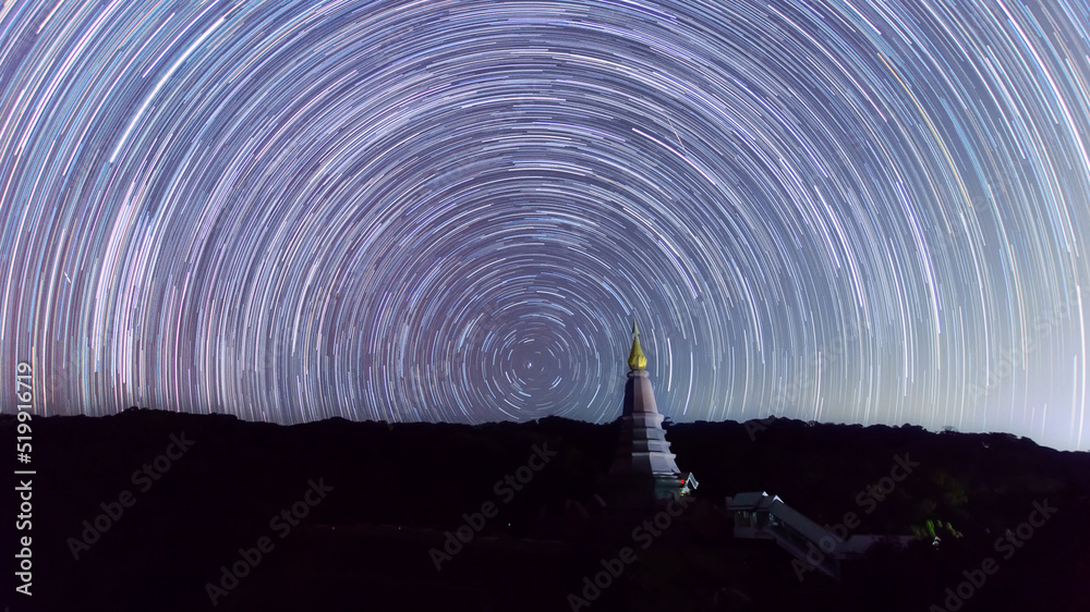 Wall mural the milky way galaxy moving over a sacred temple at doi inthanon national park, chiang mai, thailand