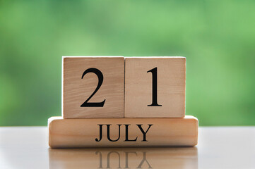 July 21 calendar date text on wooden blocks with blurred background park. Concept