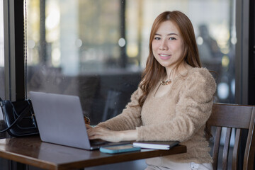 Fototapeta na wymiar Freelancer Business asian woman or study online asian girl student having coffee and doing har work in cafe.