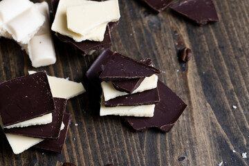 broken into pieces tiles of white and milk and dark chocolate