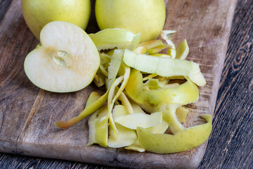 sliced and peeled green apple on a wooden board