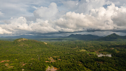 Fototapeta na wymiar Mountains covered rainforest, trees and blue sky with clouds. Sri Lanka