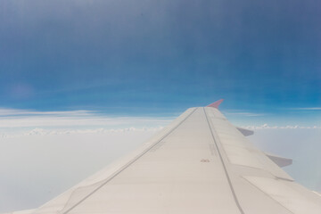 Fototapeta na wymiar Wing of airplane with blue sky and cloud on day scene