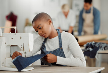 Fashion, design and creative work at a workshop. Young african American factory worker sewing new,...