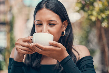Woman relaxing holding coffee in joy outside. Peaceful, calm and stressless female sipping a mug of...