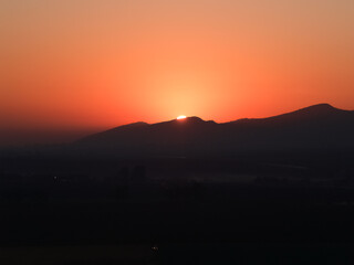In silhouette African landscape at sunset with bright red and orange color sky in South Africa