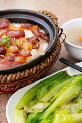 angle view clay pot rice of Chinese style sausage and air-dried bacon with soup and cabbage vertical composition