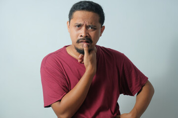 confused man with hand in waist while looking at camera