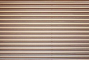 Obraz premium Corrugated metal roller shutter texture. Champagne gold steel door for background.