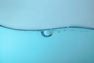 de-focused. Closeup of light blue transparent clear calm water surface texture with splashes and bubbles. Trendy abstract summer nature background. for a product, advertising,text space.