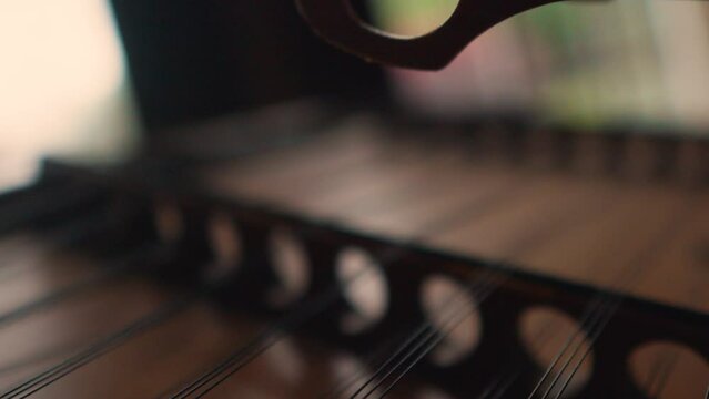 Extreme close up of dulcimer Appalachian traditional musical instrument, cinematic slow motion hammered string