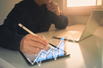 businessman working with statistics, looking at laptop and phone screens with graphs and diagrams, synchronizing electronic devices, checking financial report presentation, sitting at desk