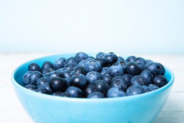 Blueberries in a blue bowl on a wooden table