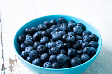 Blueberries in a blue bowl on a wooden table
