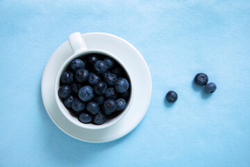 Top view of blueberry tea mug on blue fabric surface