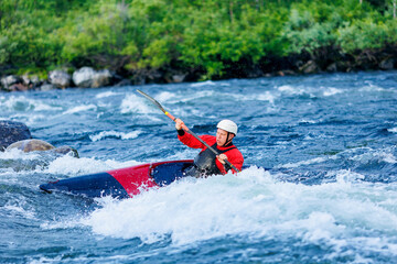 Extreme water sports, rafting on mountain river in kayak. Kayaker man strives for victory, boating...