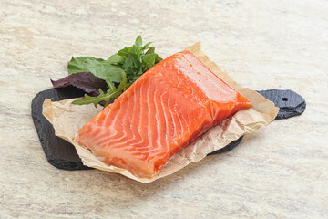 Raw salmon fillet over board