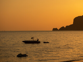 Silhouette of a boat at sunset on the water.