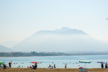 people on the beach against the backdrop of the mountains