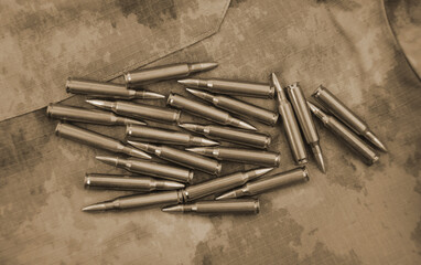 Rifle cartridges on a camouflage background. Top view. Sepia