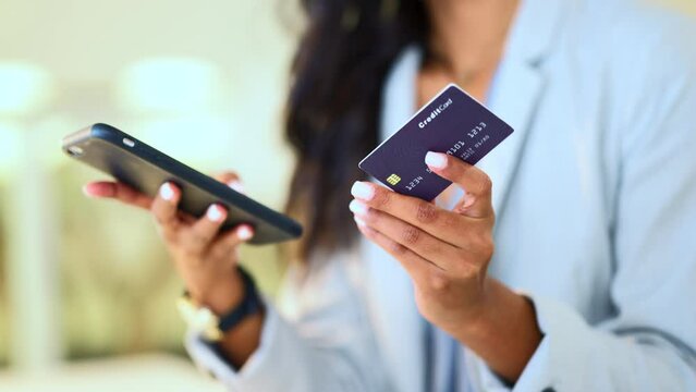 Bank card data put in phone by a woman doing internet shopping and banking to make an online credit payment. Lady typing on her phone to send money via an ewallet transaction