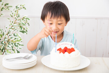 誕生日ケーキにローソクを立てる男の子　birthday