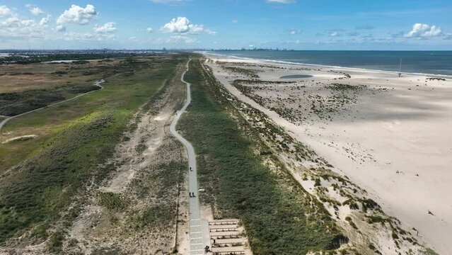 Flight along lush green Kijkduin dunes and artificial Zandmotor beach; drone