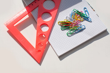 Ruler and multicolored paper clips on a white background. School supplies