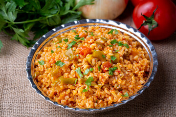 Traditional turkish bulgur pilaf with tomato sause in plate (Turkish name; meyhane pilavi)